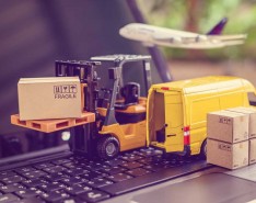 toy forklift and van on keyboard to illustrate supply chain
