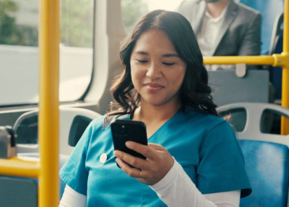 health care aide on bus looking at phone