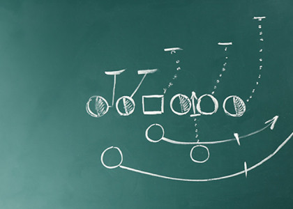 A chalkboard with a football strategy drawn in chalk with various shapes