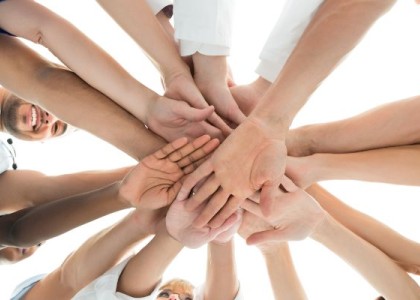 health care professionals putting their hands in to a pile for a celebration cheer