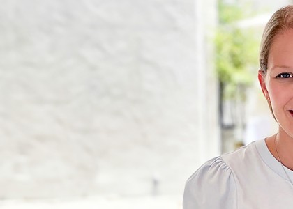Amy Marchant sits and smiles in front of a white background.