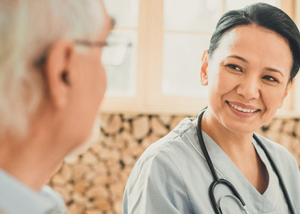 A physician sitting with an elderly patient.