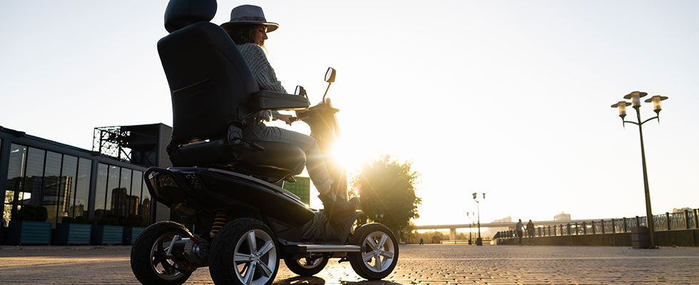 Person driving a powerchair at sunset