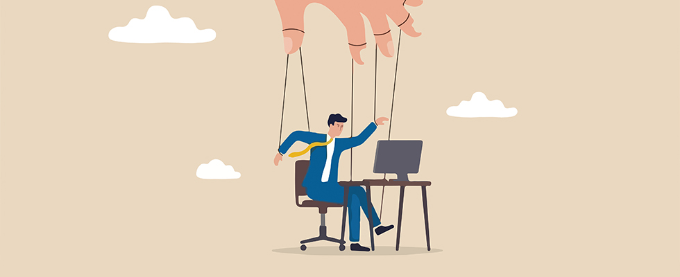 An illustration of a man at a desk with a puppeteer hand over him to symbolize mircomanagement